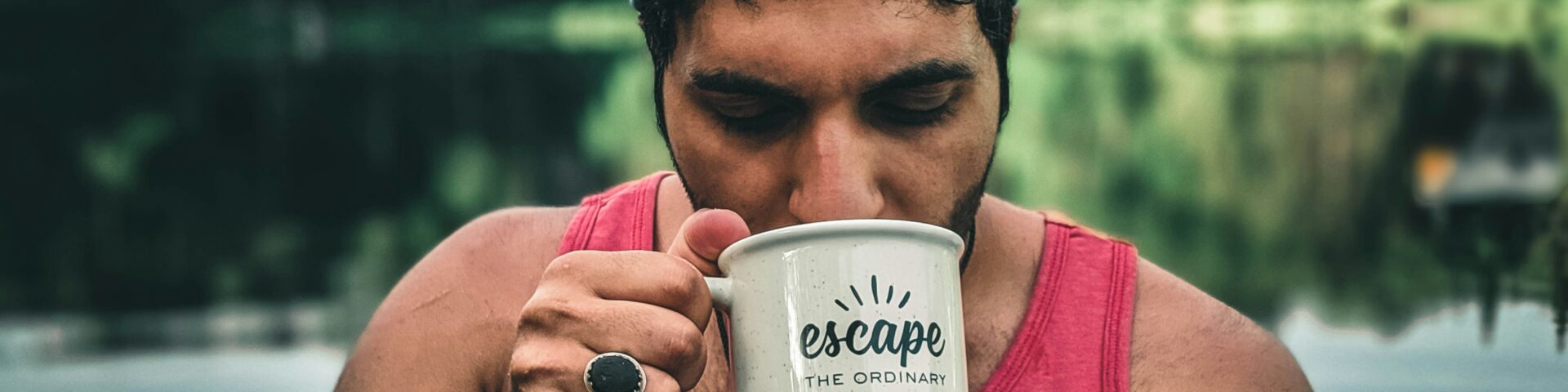 woman in pink tank top holding white ceramic mug